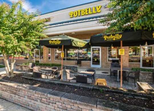 the outside of a restaurant with tables and umbrellas