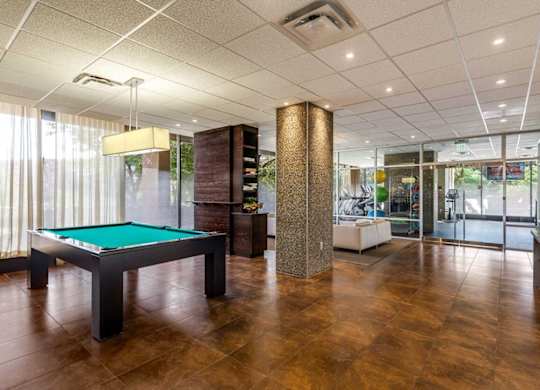 A room with a pool table and a bar.
