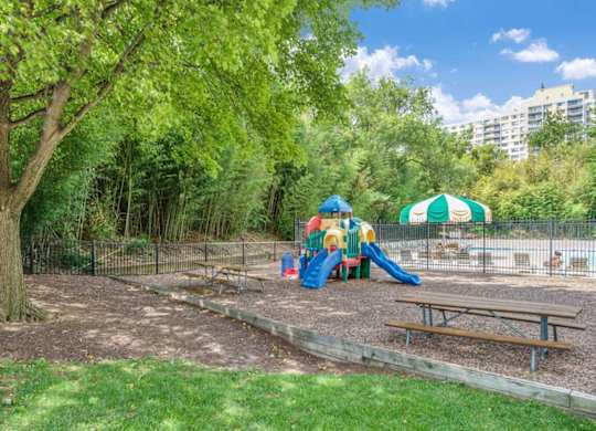 A playground with a slide, swings, and a picnic table.