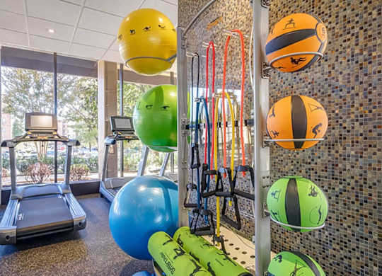 A gym with exercise balls and a treadmill.
