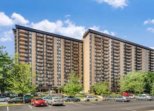 A large apartment building with a parking lot in front.