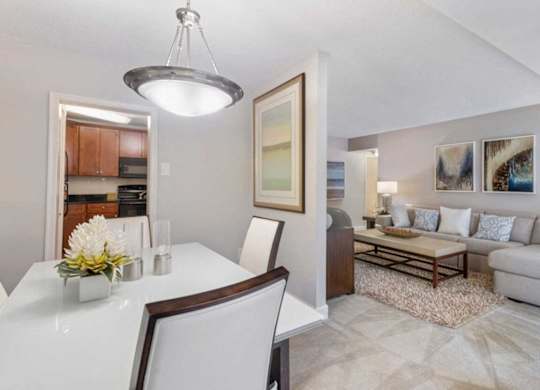 A modern dining room with a white table and chairs.