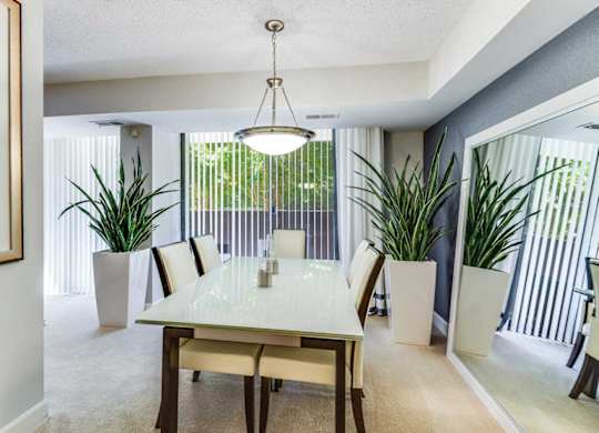 A dining room with a table and chairs.