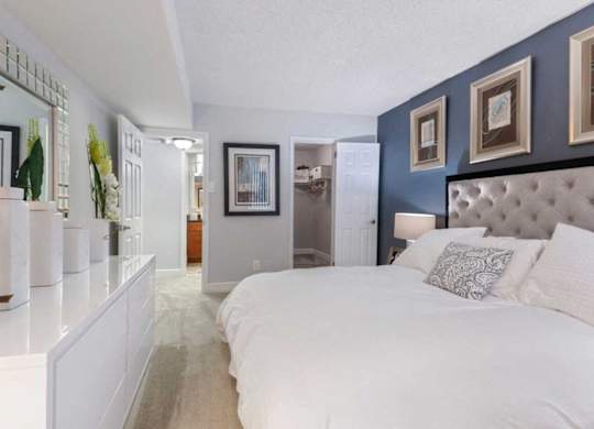A bedroom with a large bed and a mirror on the wall.