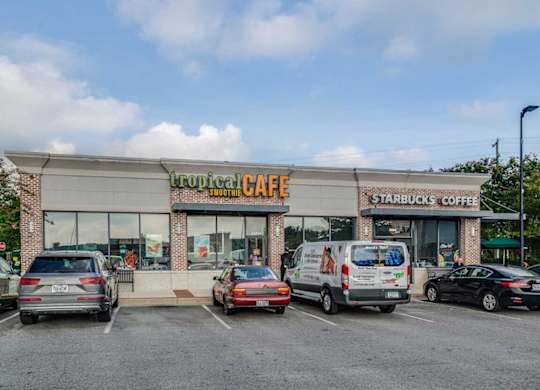 A Starbucks Coffee shop with a parking lot in front.