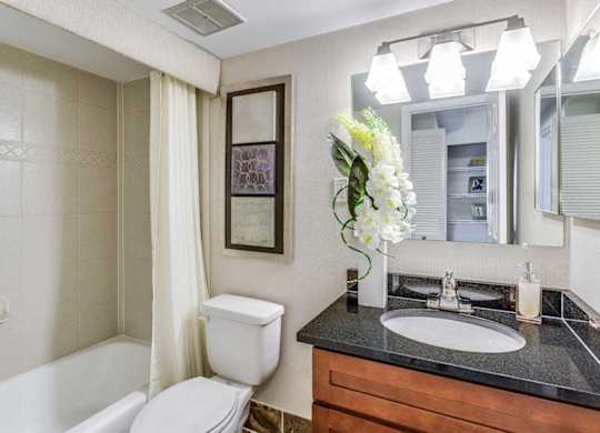A bathroom with a white toilet, a sink, and a bathtub.