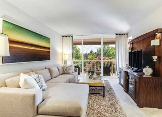 A living room with a large couch and a painting on the wall.