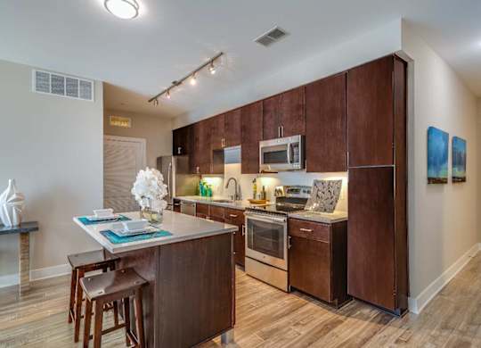 A kitchen with brown cabinets and a wooden island.