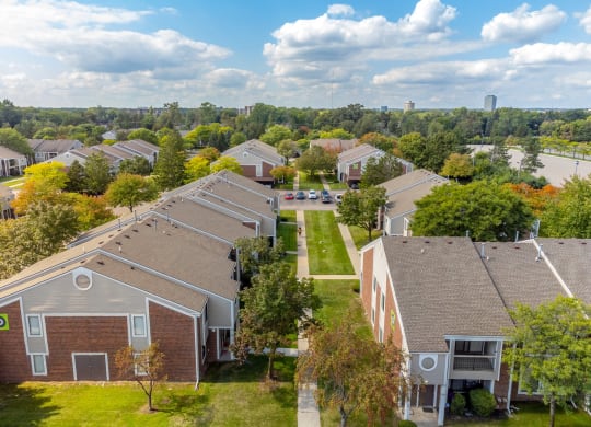 an aerial view of a neighborhood of houses with trees and a river
