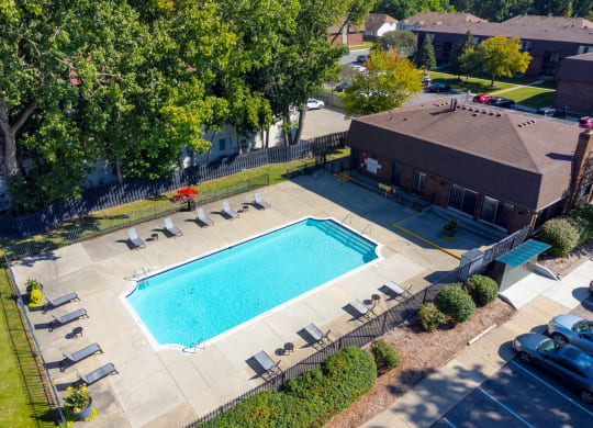 Large open area with heated pool and lounge chairs at Knottingham Apartments in Clinton Township, MI