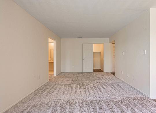 Open and airy carpeted living room at Knottingham Apartments in Clinton Township, MI