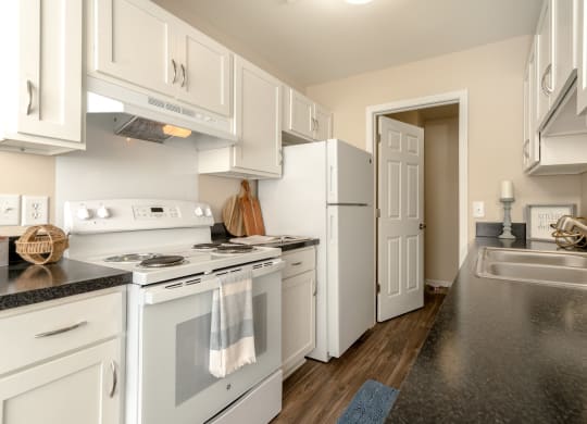 Kitchen with White Cabinets and Appliances at Three Oaks Apartments in Troy, MI