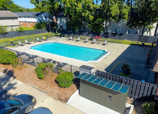 Open and heated pool space with lounge chairs and 24/7 secured package lockers at Knottingham Apartments in Clinton Township, MI