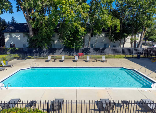 Heated Pool patio with lounge chairs at Knottingham Apartments in Clinton Township, MI