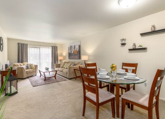 a living room and dining room with a table and chairs
