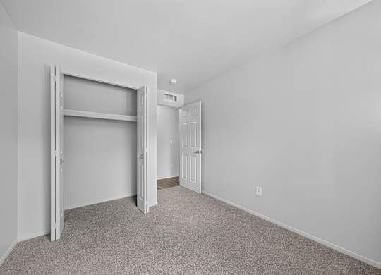 Cozy bedroom with ample storage at Woodland Villa Apartments in Westland, MI.