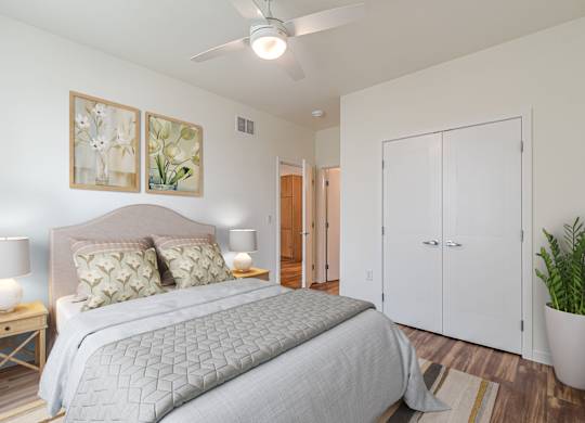 A bedroom with a large bed and a ceiling fan.