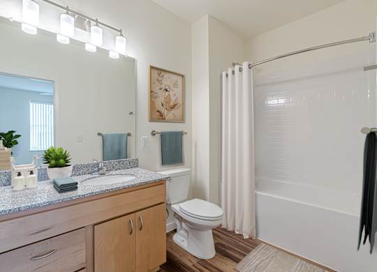 A bathroom with a toilet, sink, and shower.