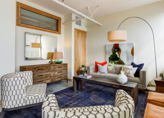 Living room with comfortable chair at Arcade Artist Apartments, Missouri