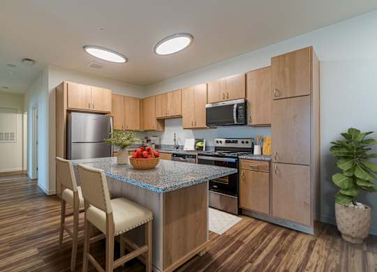 A kitchen with wooden cabinets and a granite countertop.