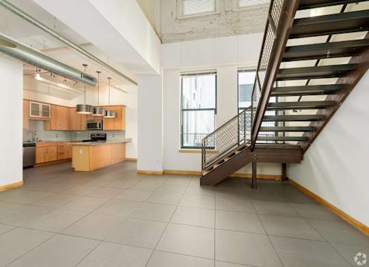A spacious kitchen with a staircase leading to the upper floor.