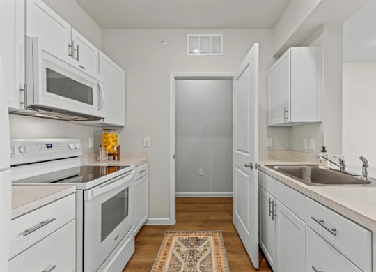 a renovated kitchen with white cabinets and stainless steel appliances at Cypress Creek at River Oaks, Waxahachie Texas