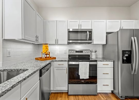 a kitchen with stainless steel appliances and white cabinets at Cypress Creek at River Oaks, Waxahachie, TX