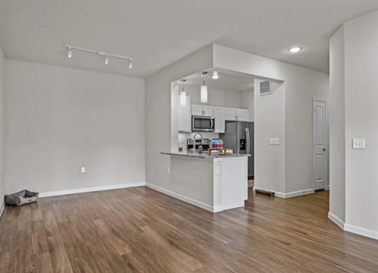 a living area with a kitchen and a hard wood floor at Cypress Creek at River Oaks, TX 75165