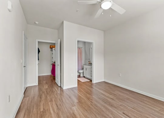 a living room with white walls and a ceiling fan at Cypress Creek at River Oaks, Waxahachie