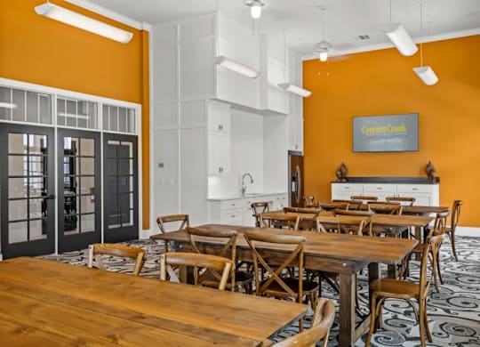 a dining room with tables and chairs and a kitchen at Cypress Creek at River Oaks, TX 75165