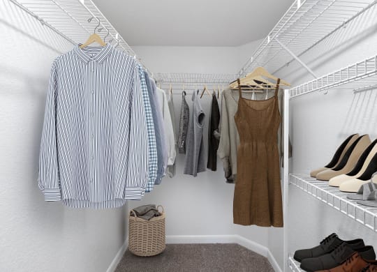 a walk in closet filled with clothes and shoes
