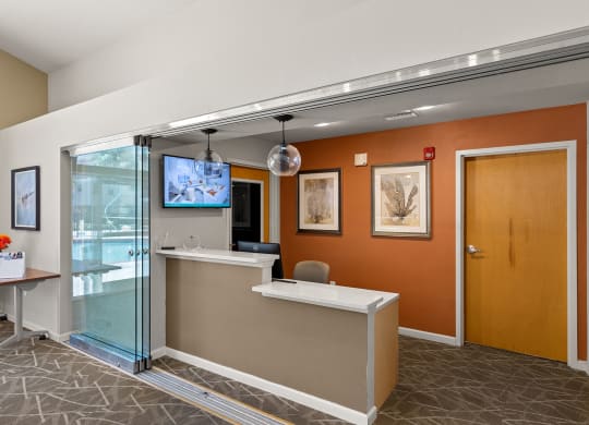 an office lobby with a reception desk and a tv