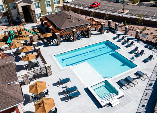 an overhead view of a swimming pool with chairs and umbrellas