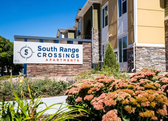 the front of the south range crossings apartment building with flowers