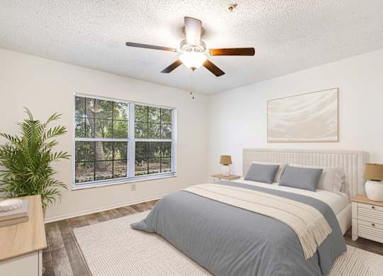 A bedroom with a large bed and a ceiling fan.