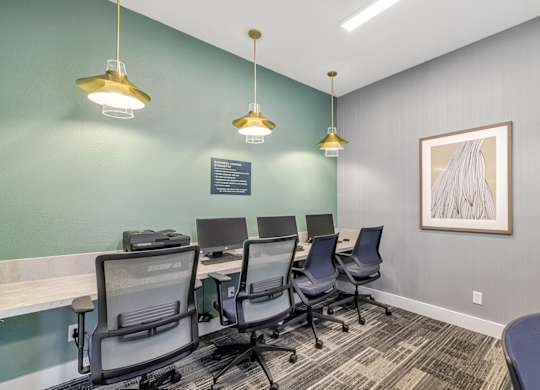 A room with a green wall and a painting on the wall.