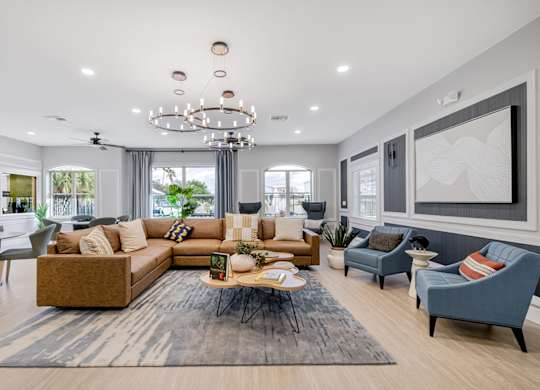 A modern living room with a large sectional sofa and a coffee table in the center.