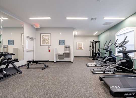 A gym with treadmills, elliptical machines, and other exercise equipment.