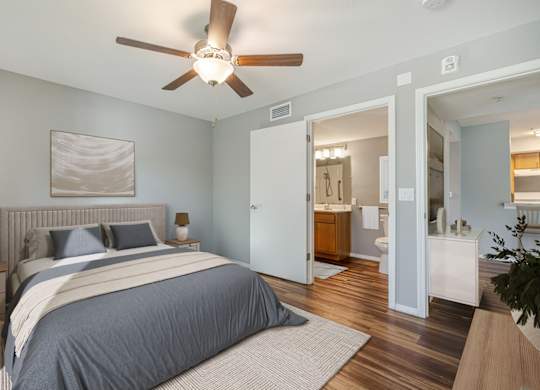A bedroom with a large bed and a ceiling fan.