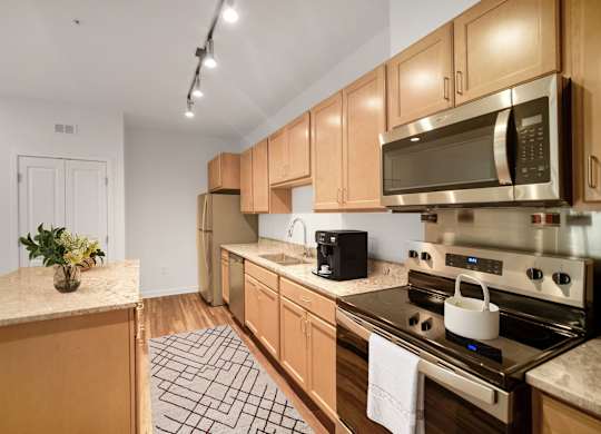 A kitchen with wooden cabinets and a white counter top.at Creekridge on The Park, Charlotte, NC 28212