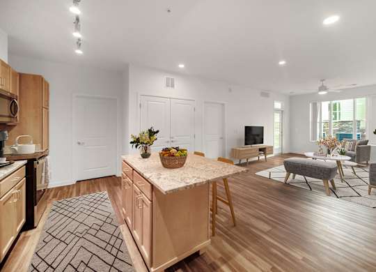 A modern kitchen with wooden cabinets and a central island.at Creekridge on the Park, Charlotte