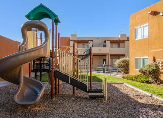 A playground with a slide and a climbing frame.