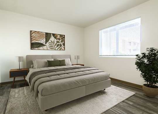 A bedroom with a large bed and a potted plant.