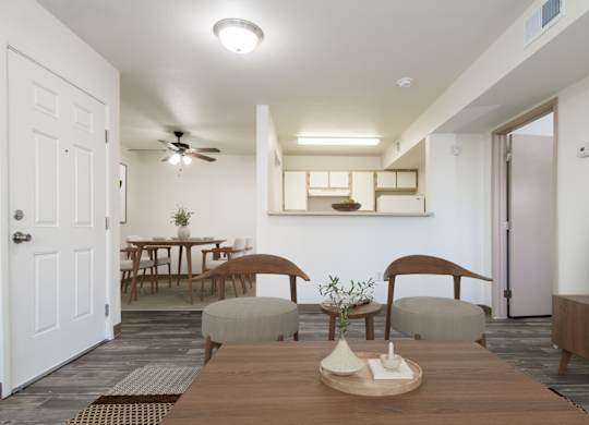 A modern dining room with a wooden table and chairs.