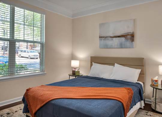 A bedroom with two beds and a painting on the wall.