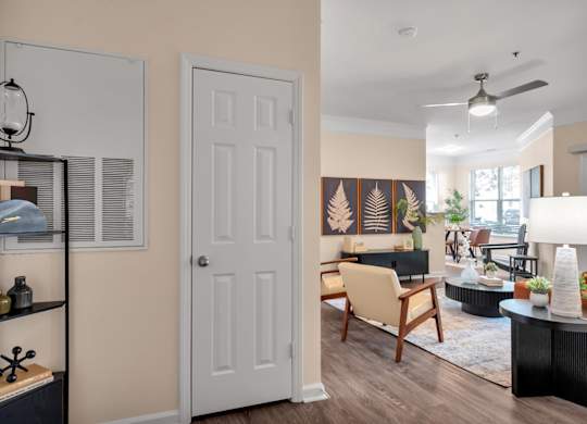 A living room with a white door and a wooden chair.