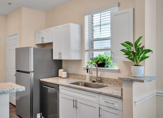 A kitchen with a granite countertop and white cabinets.
