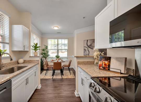 A kitchen with a black stove top oven and a sink with a faucet.