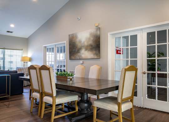 A dining room with a table and chairs.