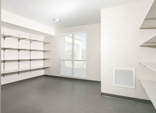 A room with a window and shelves on the wall.